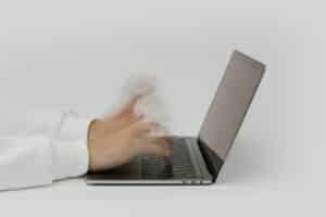 Hands typing fast on a Laptop keyboard to monitor email delivery duration